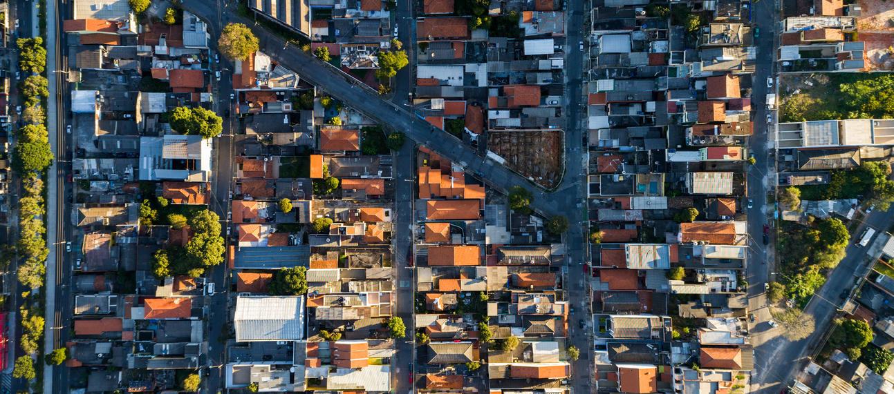 A neighbourhood of buildings seen from above, with two main streets converging in the middle. 