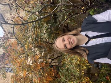 Aniela Bankowicz has long blonde hair and is wearing a gradualtion gown.